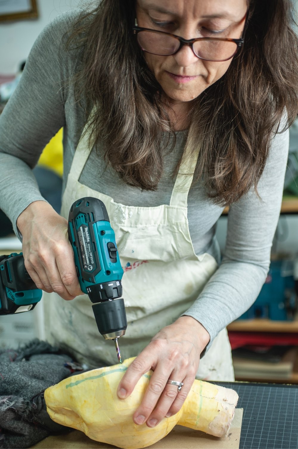Tiina is drilling a hole in a puppet head