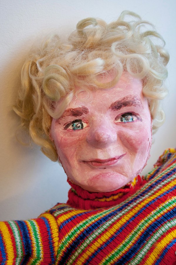 En mannlig look-alike figur med hvitt krøllete hår og stripete genser