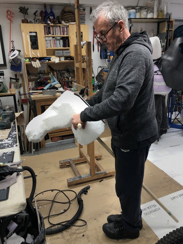 Sean holding a white foam hobby donkey in profile.